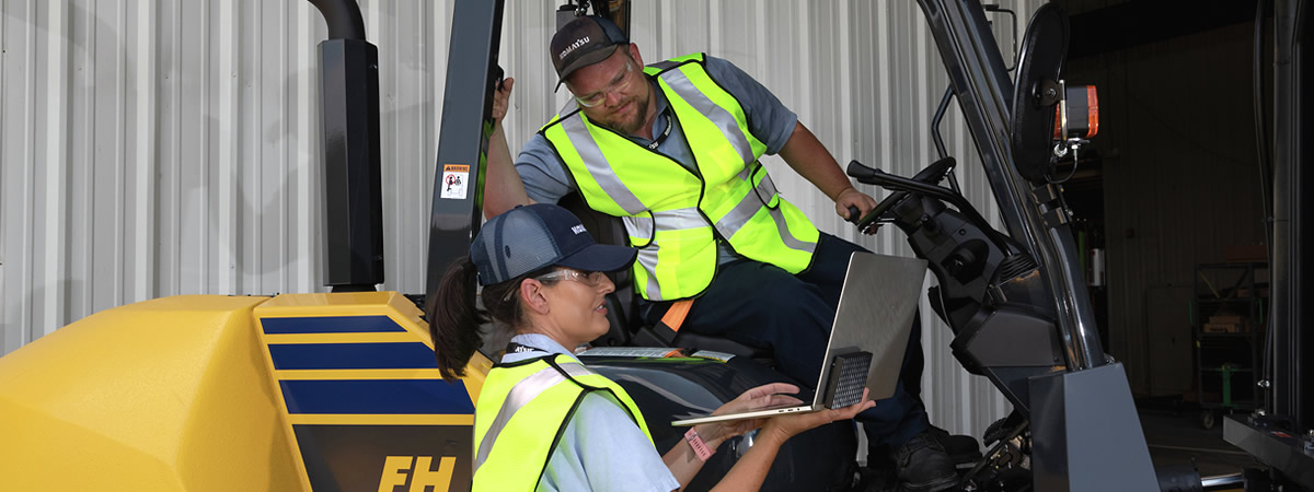 two men working on a forklift